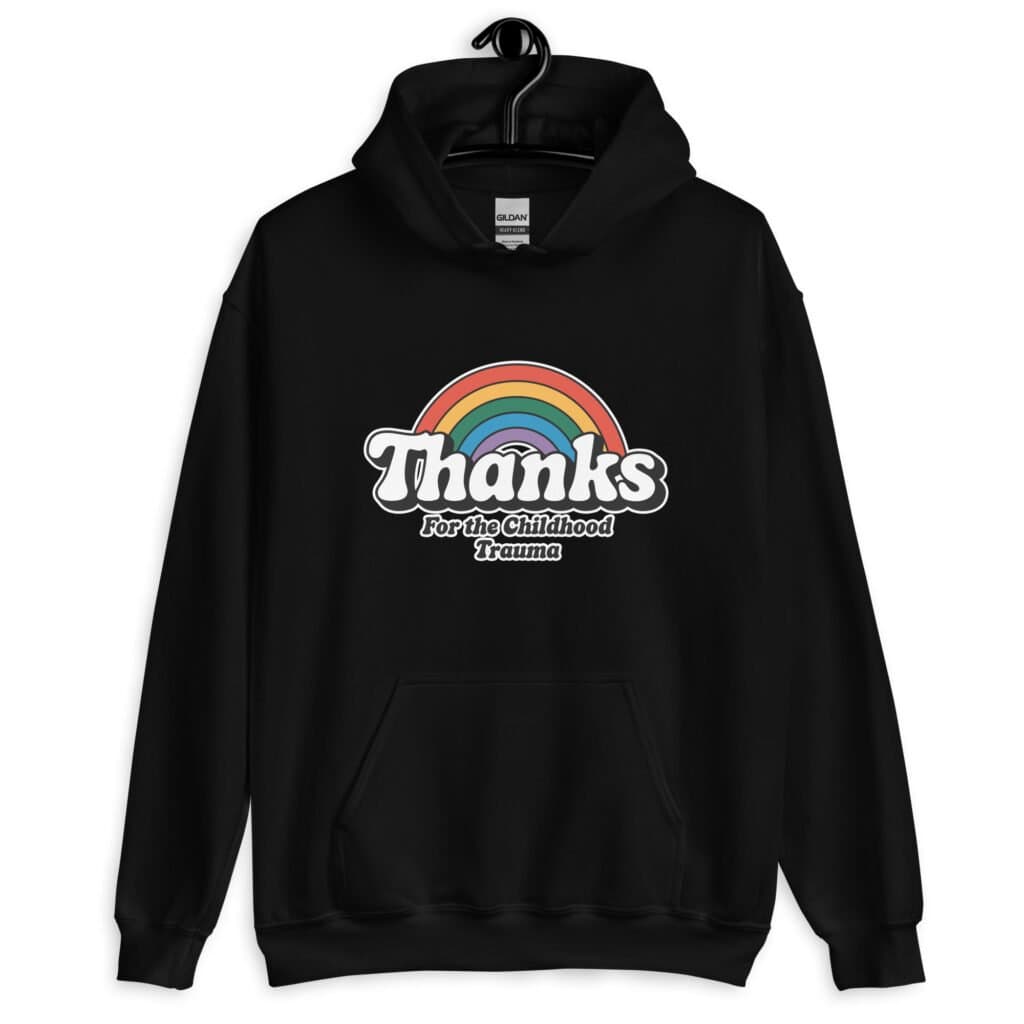 Black hoodie sweatshirt with an image of a rainbow and the words 'Thanks for the childhood trauma' printed on the front. The word Thanks is large and the rest of the words are smaller under.