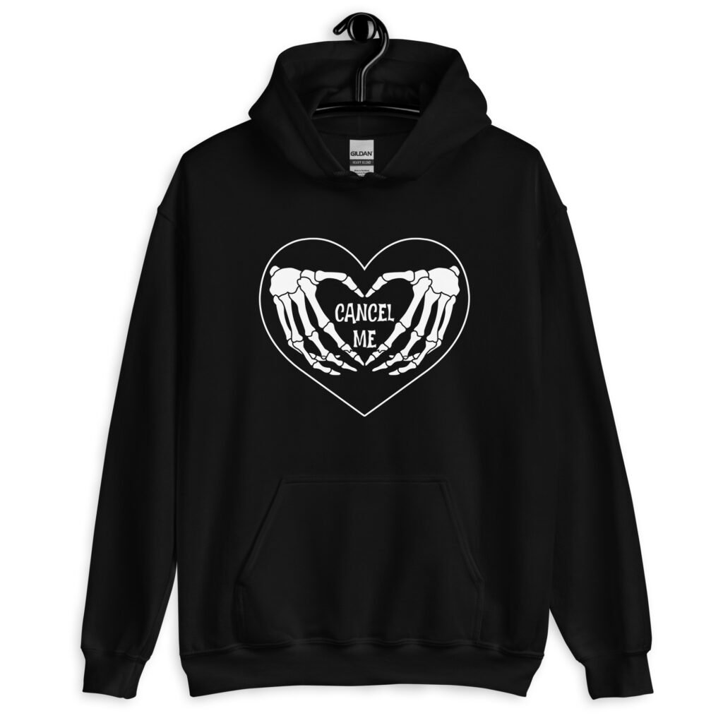Black hoodie sweatshirt with a heart and skeleton hands making a heart shape printed on the front. The words 'Cancel Me' are inside of the heart.