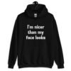 Black hoodie sweatshirt with the text 'I'm nicer than my face looks' printed on the front.