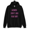 Black hoodie sweatshirt with the words 'Women don't owe you shit' printed on the front in pink.