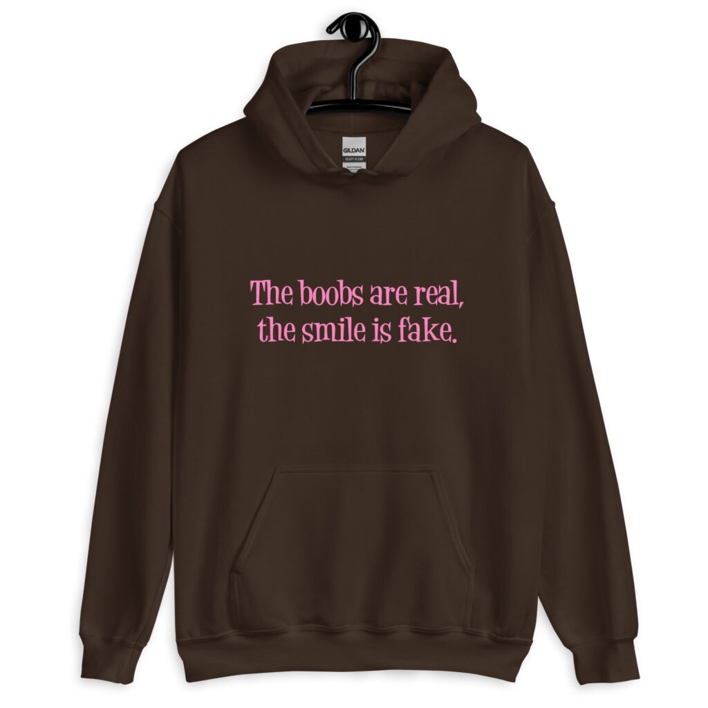 Dark chocolate brown hoodie sweatshirt with the text 'The boobs are real, the smile is fake.' printed in pink on the front.