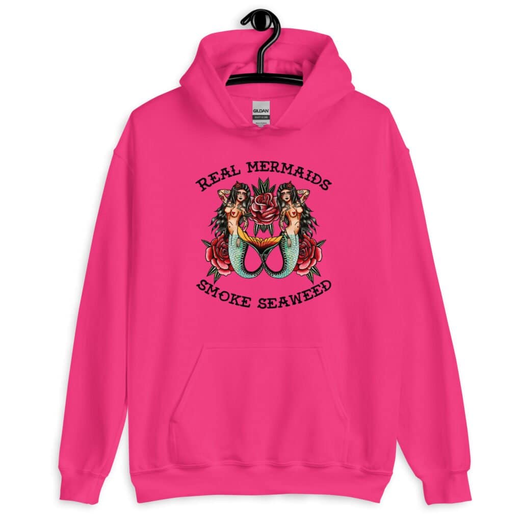 Heliconia pink hoodie sweatshirt with image of 2 mermaids and the text 'Real mermaids smoke seaweed' printed on the front.