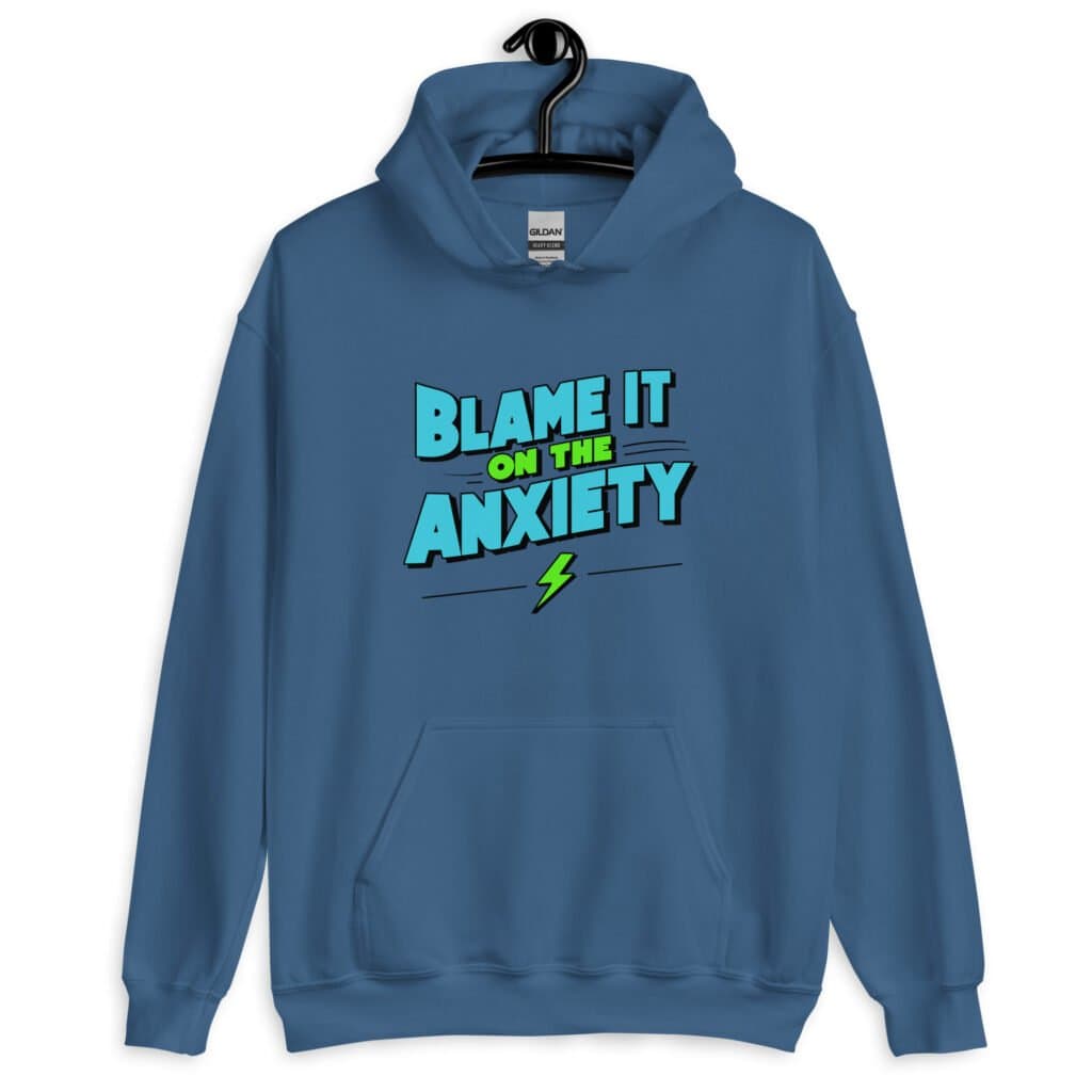 Indigo blue hoodie sweatshirt with the phrase 'Blame is on the anxiety' printed on the front. The graphics are bold and in aqua and lime green.