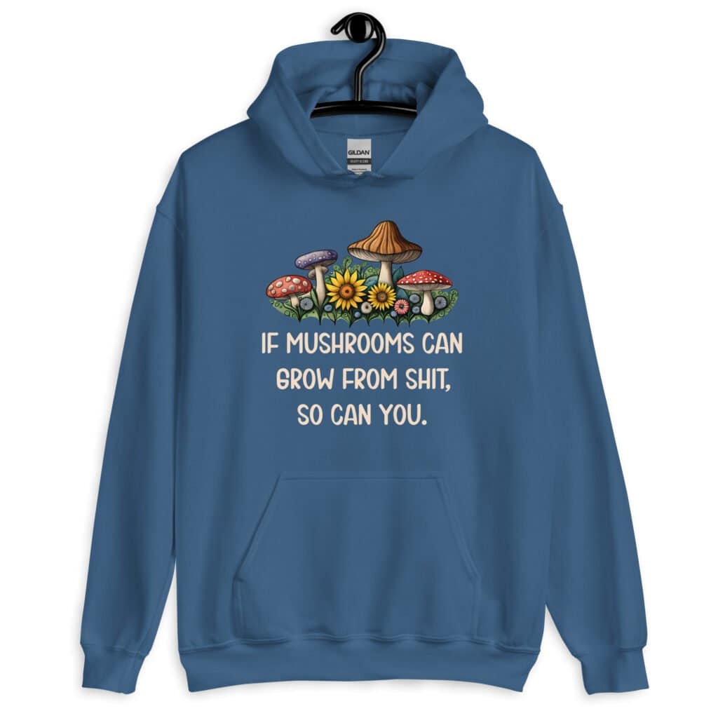 Indigo blue hoodie sweatshirt with images of mushrooms and the text 'If mushrooms can grow from shit, so can you.' printed on the front.
