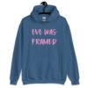 Indigo blue hoodie sweatshirt with the text 'Eve was framed' printed on the front in pink.