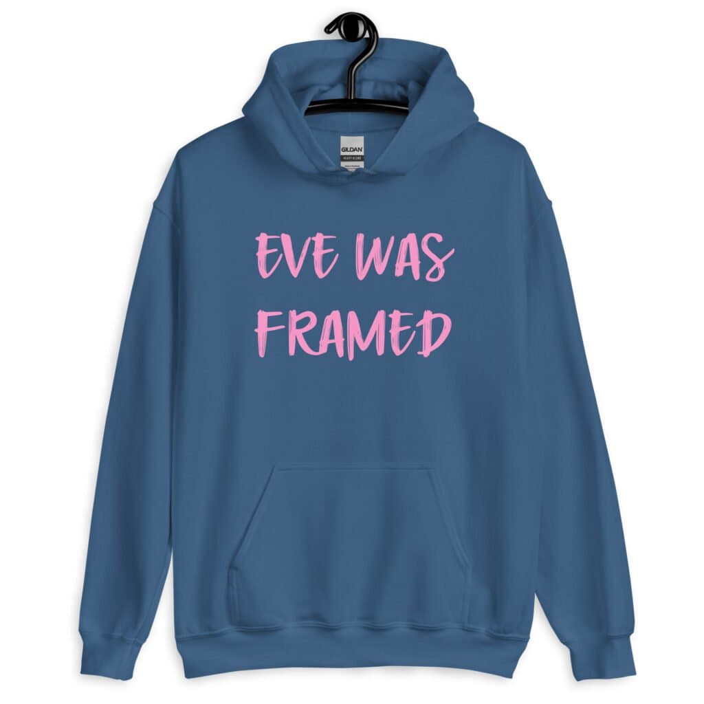 Indigo blue hoodie sweatshirt with the text 'Eve was framed' printed on the front in pink.