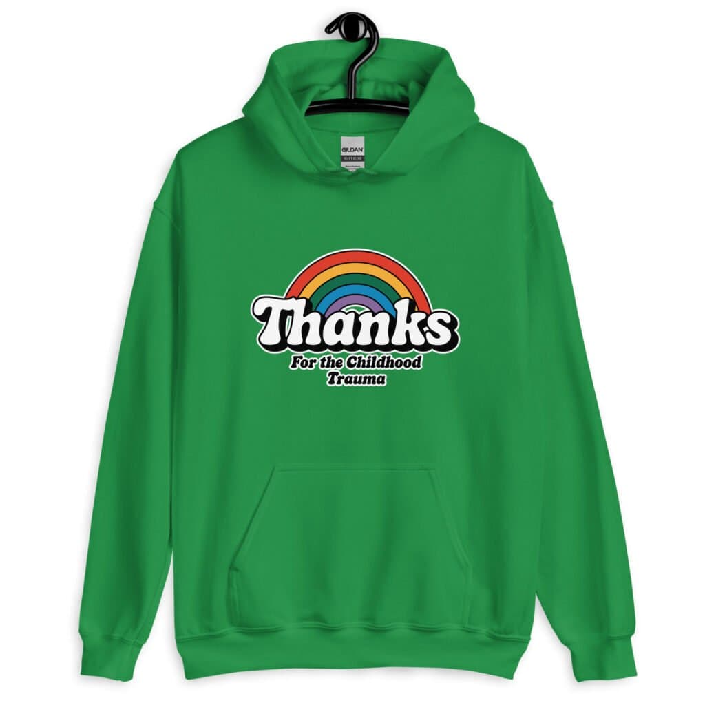 Green hoodie sweatshirt with an image of a rainbow and the words 'Thanks for the childhood trauma' printed on the front. The word Thanks is large and the rest of the words are smaller under.