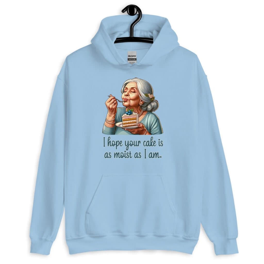 Light blue hoodie sweatshirt with an image of grey haired older woman enjoying a bite of a piece of cake with the words 'I hope your cake is as moist as I am' printed on the front.