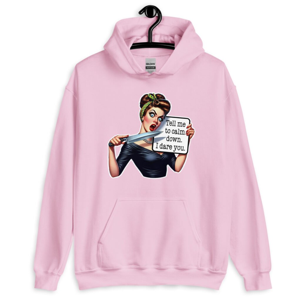 Light pink hoodie sweatshirt that has a graphic of an angry looking retro woman holding a knife and a sign. The sign says 'Tell me to calm down. I dare you.' The graphic is printed on the front of the hoodie.