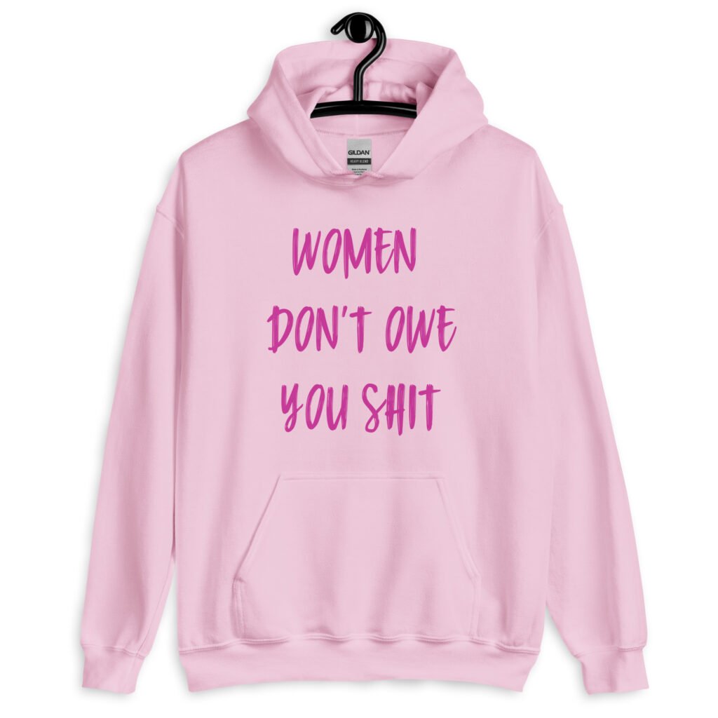 Light pink hoodie sweatshirt with the words 'Women don't owe you shit' printed on the front in pink.