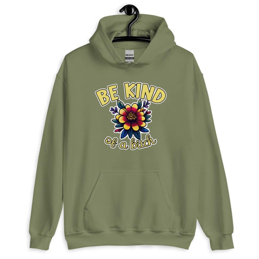 Military green hoodie sweatshirt with an image of a flower and the words Be kind above the flower in yellow bold block font. The words Of a bitch are smaller in script font under the flower. The design is printed on the front.