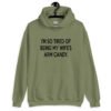 Military green hoodie sweatshirt with the funny phrase 'I'm so tired of being my wife's arm candy' printed on the front.