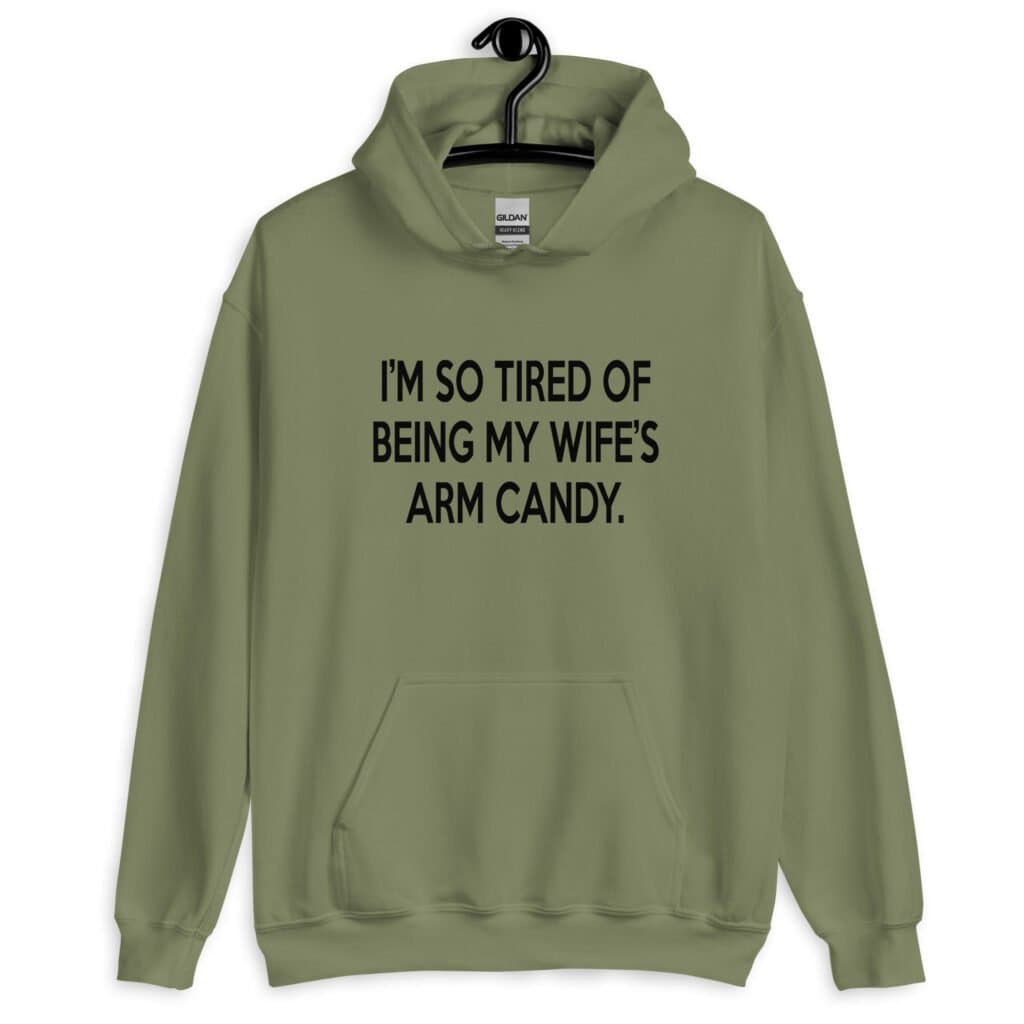 Military green hoodie sweatshirt with the funny phrase 'I'm so tired of being my wife's arm candy' printed on the front.