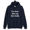 Navy blue hoodie sweatshirt with the text 'I'm nicer than my face looks' printed on the front.