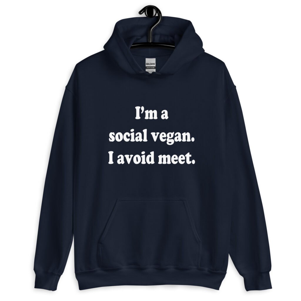 Navy blue hoodie sweatshirt with the pun phrase 'I'm a social vegan. I avoid meet.' printed on the front.