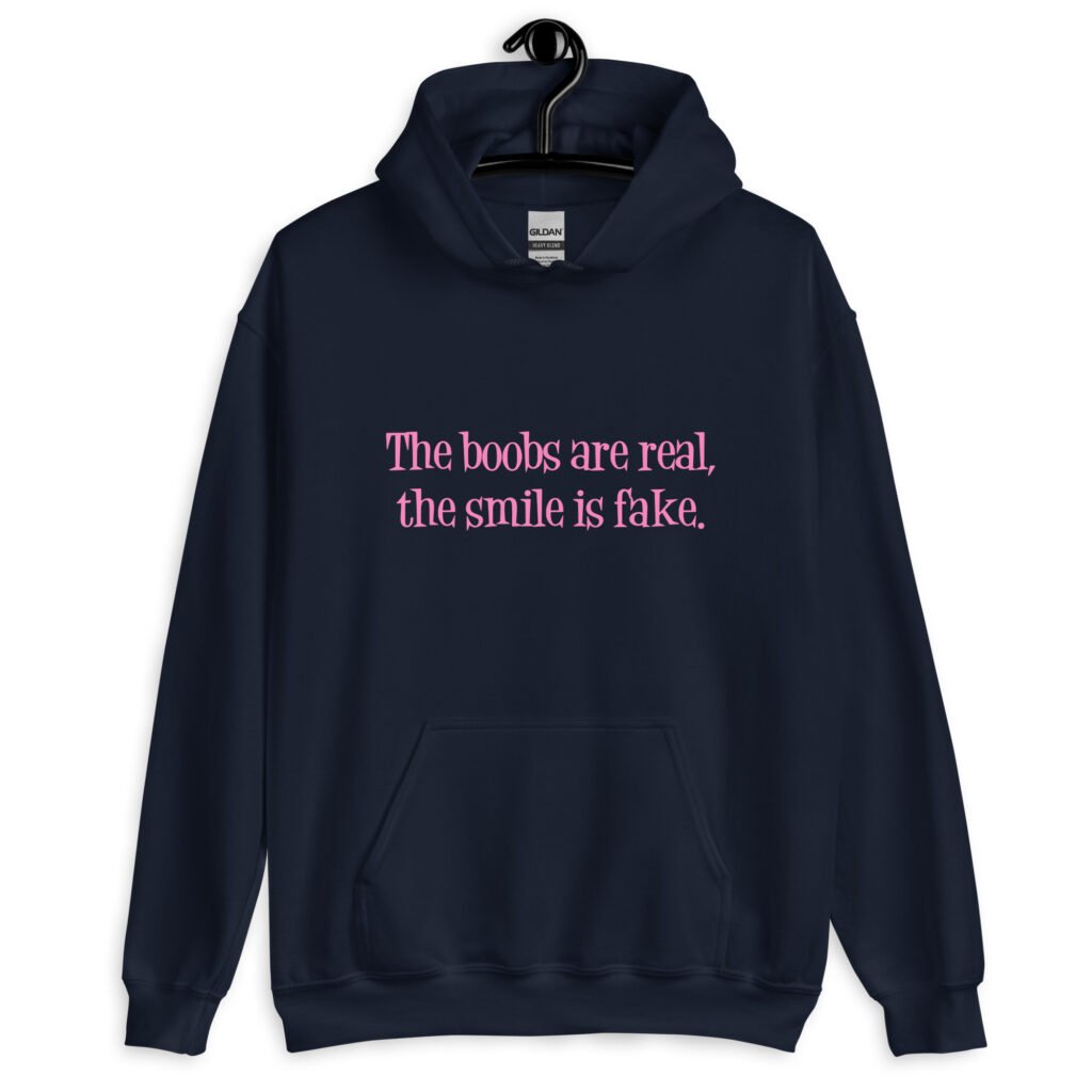 Navy blue hoodie sweatshirt with the text 'The boobs are real, the smile is fake.' printed in pink on the front.