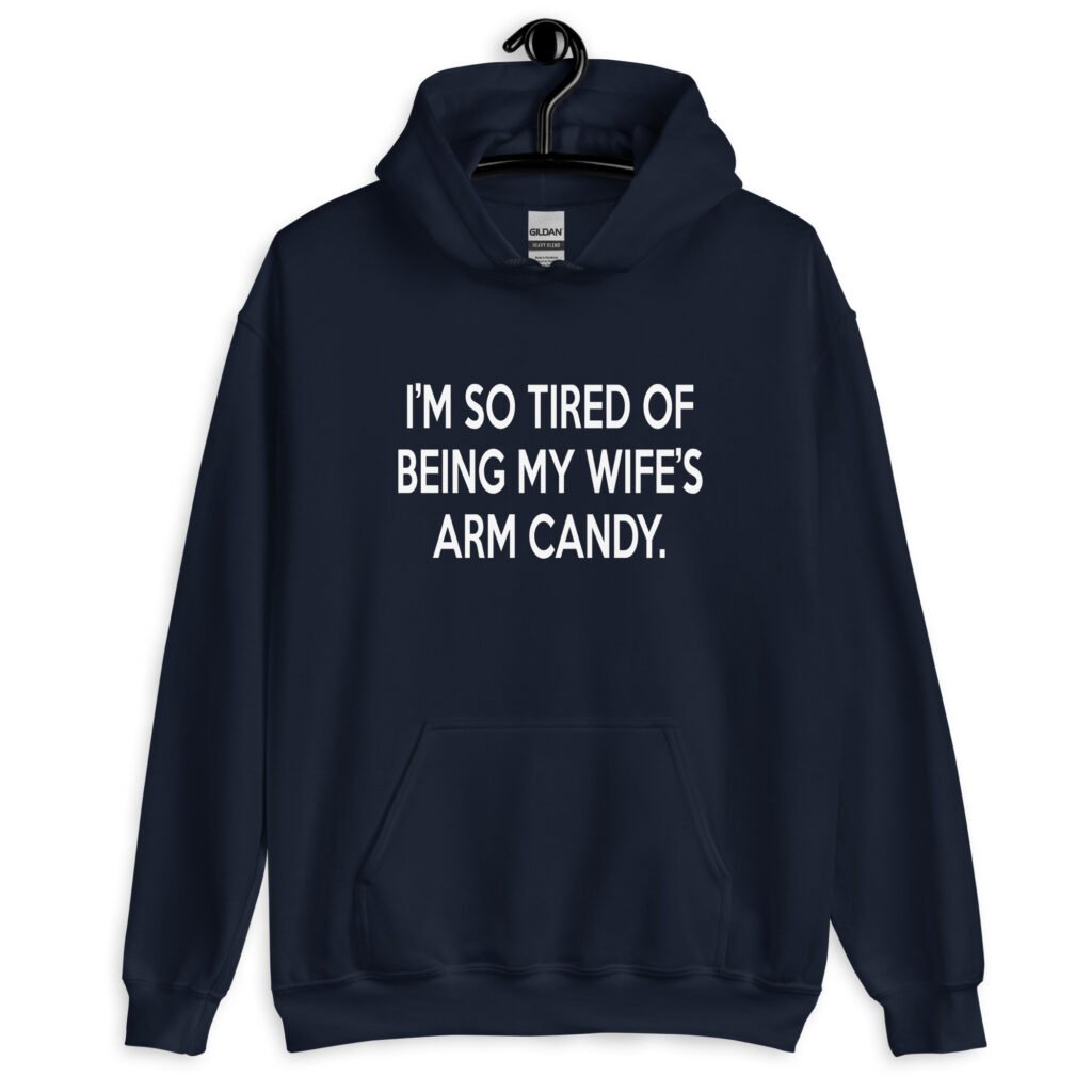 Navy blue hoodie sweatshirt with the funny phrase 'I'm so tired of being my wife's arm candy' printed on the front.