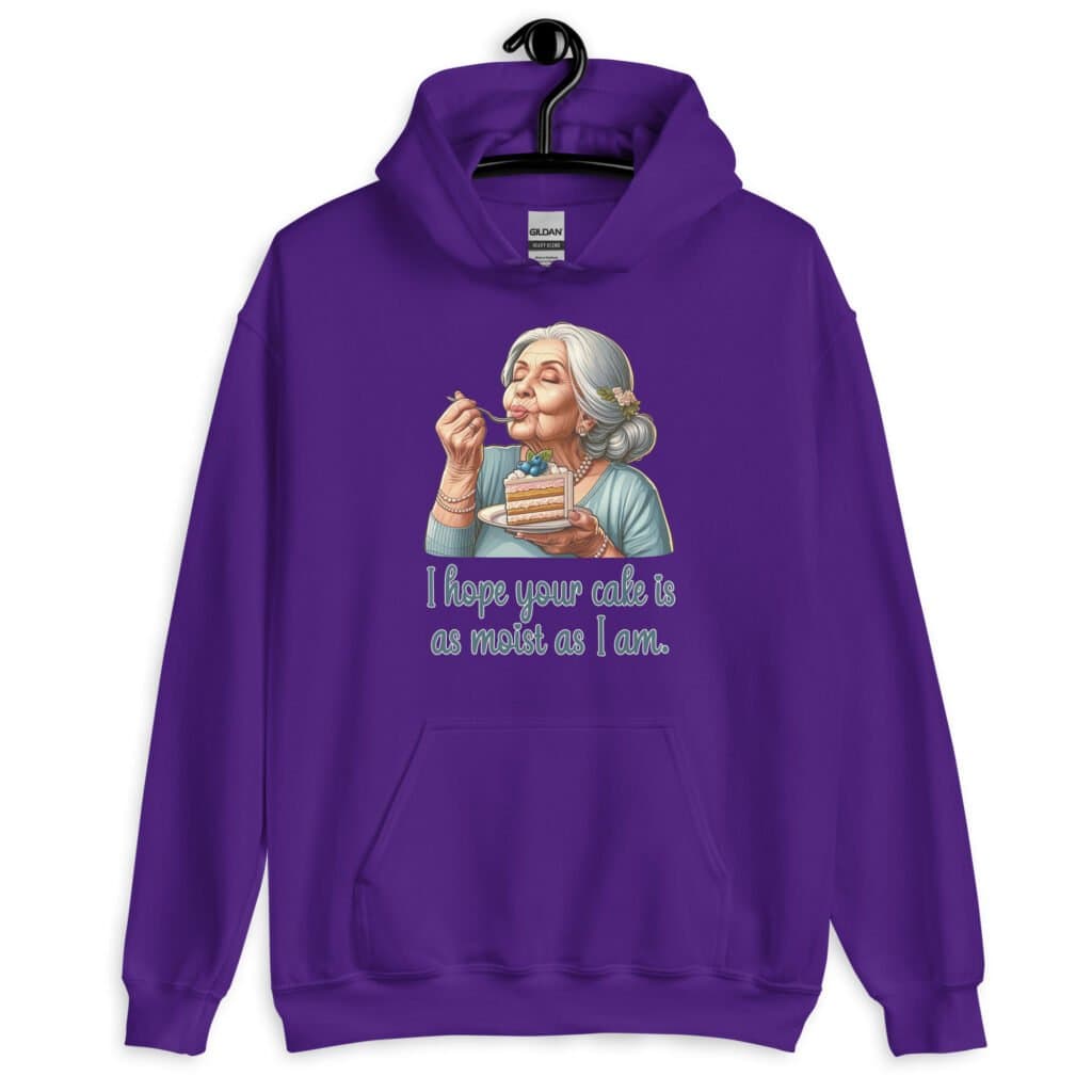 Purple hoodie sweatshirt with an image of grey haired older woman enjoying a bite of a piece of cake with the words 'I hope your cake is as moist as I am' printed on the front.