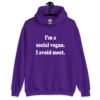Purple hoodie sweatshirt with the pun phrase 'I'm a social vegan. I avoid meet.' printed on the front.