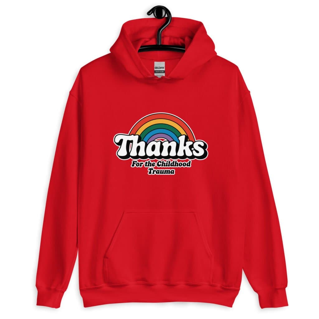 Red hoodie sweatshirt with an image of a rainbow and the words 'Thanks for the childhood trauma' printed on the front. The word Thanks is large and the rest of the words are smaller under.