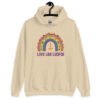 Sand color hoodie sweatshirt with an image of a boho style rainbow. There is an upside down cross in the center arch of the rainbow and the text 'Love like Lucifer' printed under. The graphics are printed on the front.
