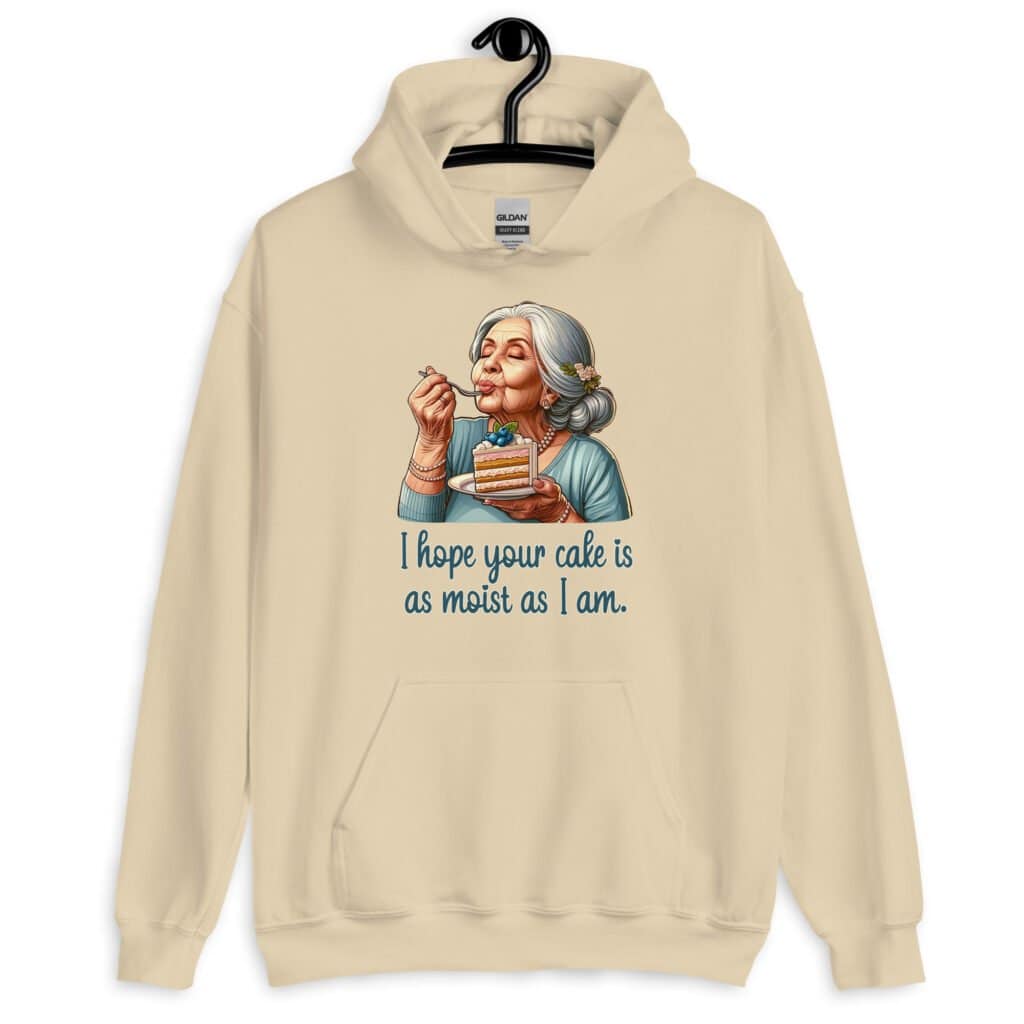 Sand color hoodie sweatshirt with an image of grey haired older woman enjoying a bite of a piece of cake with the words 'I hope your cake is as moist as I am' printed on the front.