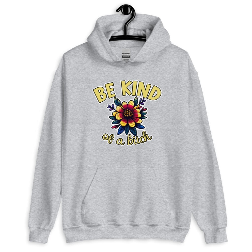 Sport grey hoodie sweatshirt with an image of a flower and the words Be kind above the flower in yellow bold block font. The words Of a bitch are smaller in script font under the flower. The design is printed on the front.