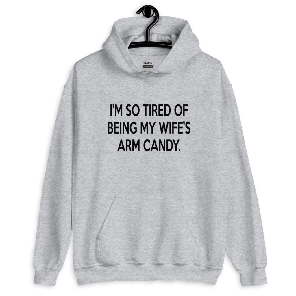 Sport grey hoodie sweatshirt with the funny phrase 'I'm so tired of being my wife's arm candy' printed on the front.
