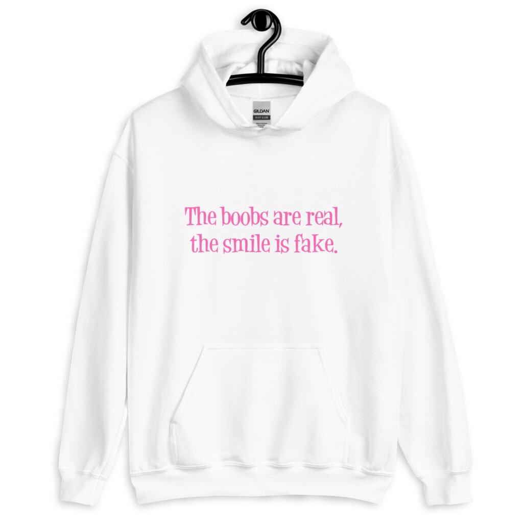 White hoodie sweatshirt with the text 'The boobs are real, the smile is fake.' printed in pink on the front.