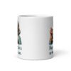 White ceramic coffee mug with an image of grey haired older woman enjoying a bite of a piece of cake with the words 'I hope your cake is as moist as I am' printed on both sides.