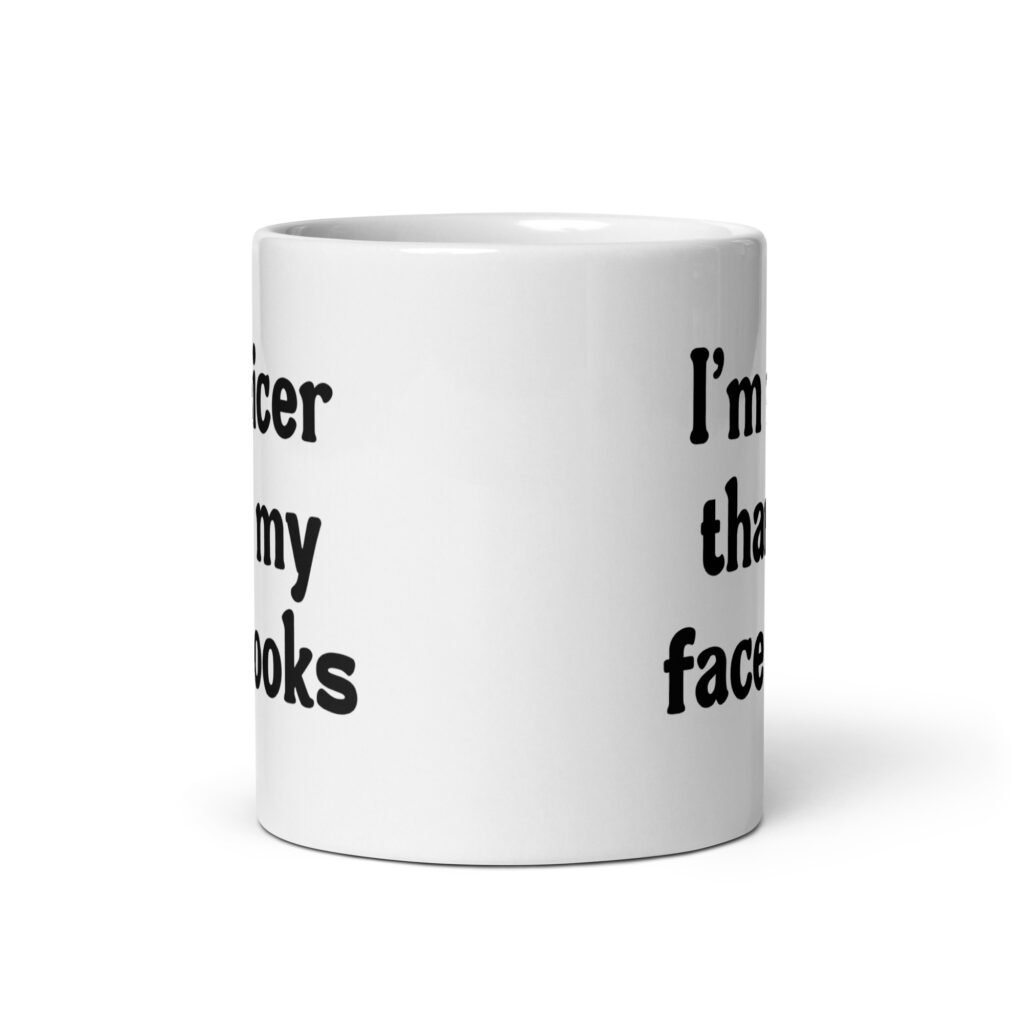 White ceramic coffee mug with the text 'I'm nicer than my face looks' printed on both sides.