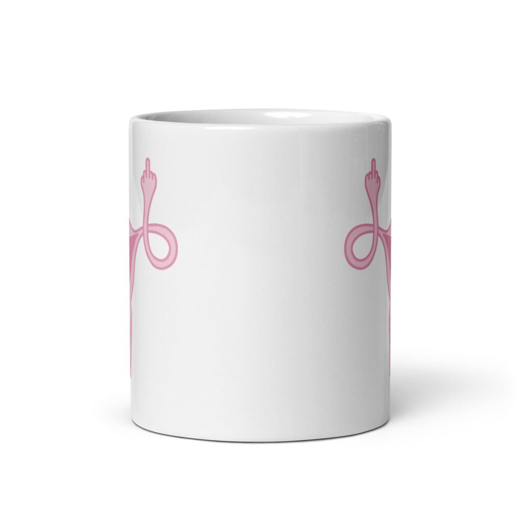 White ceramic coffee mug with with image of a pink uterus flipping middle finger graphic printed on both sides.