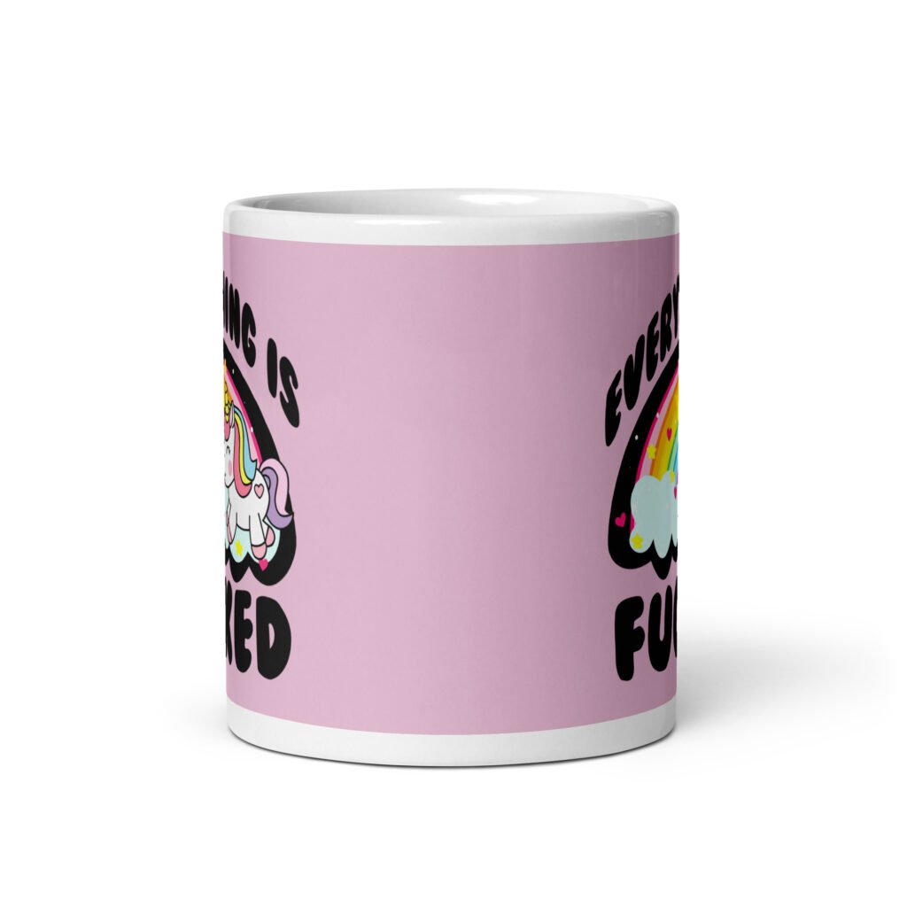 Pink and white ceramic coffee mug with a graphic of a kawaii style unicorn and a pastel rainbow with the text 'Everything is fucked' printed on both sides. The background is pink.