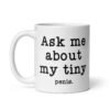 White ceramic mug with the text 'Ask me about my tiny penis' printed on both sides. The word tiny is much smaller than the rest of the text.