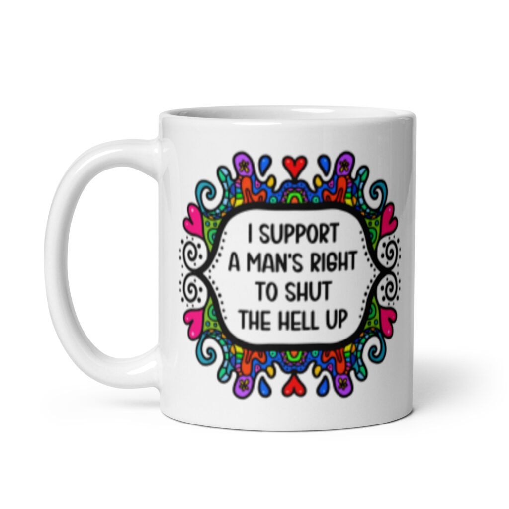 White ceramic mug with a colorful doodle graphic and the words 'I support a man's right to shut the hell up.' The design is printed on both sides of the mug.