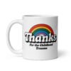 White ceramic mug with an image of a rainbow and the words 'Thanks for the childhood trauma' printed on both sides. The word Thanks is large and the rest of the words are smaller under.