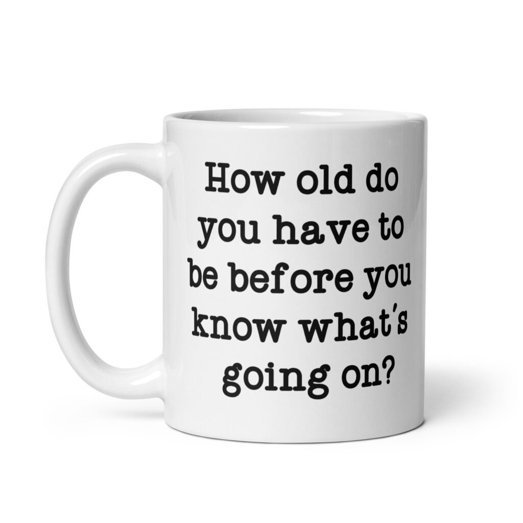 White ceramic mug with the text 'How old do you have to be before you know what's going on?' printed on both sides.
