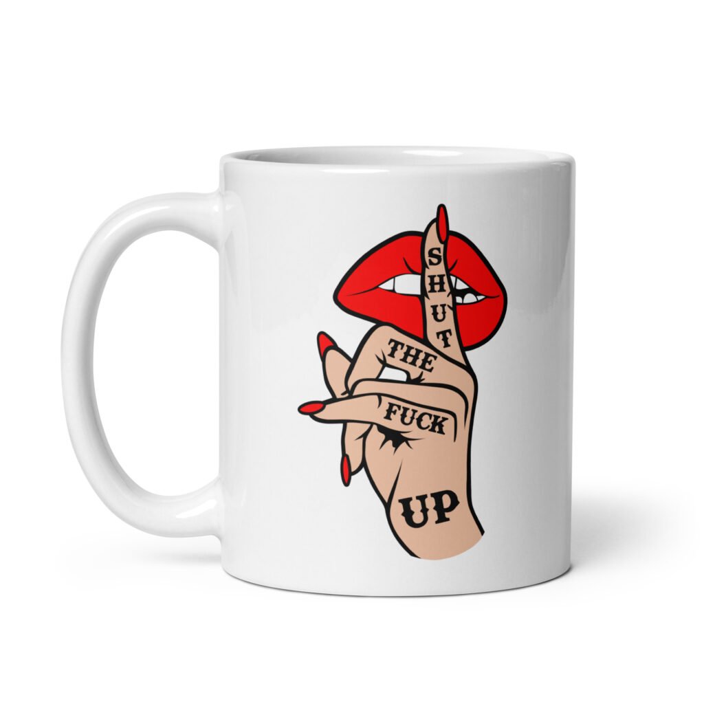 White ceramic mug with an image of a hand over lips making the shh gesture. The words 'Shut the fuck up' are printed on the hand. The graphics are printed on both sides of the mug.