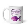 White ceramic coffee mug that has image of a purple anal plug with a smile face. There is a speech bubble above with the words 'Don't forget to stretch'. The graphics are printed on both sides of the mug.
