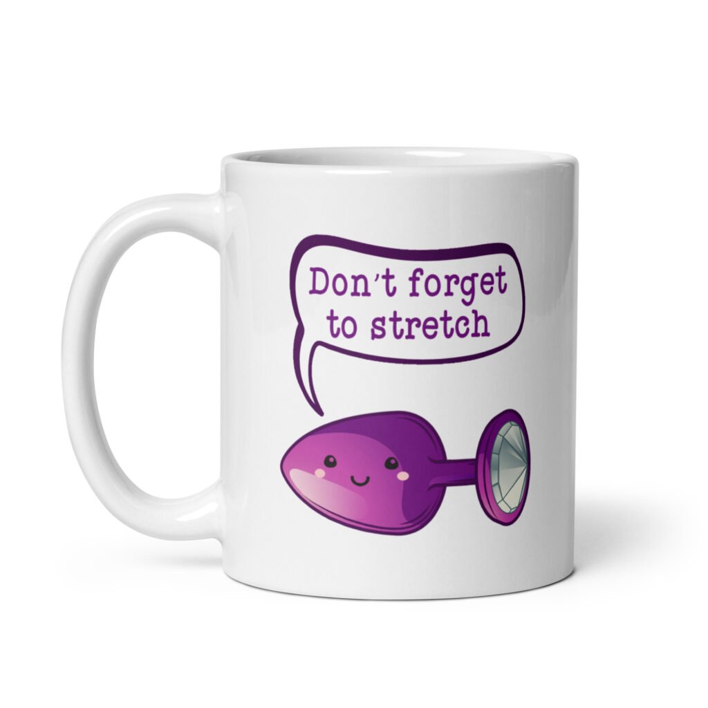 White ceramic coffee mug that has image of a purple anal plug with a smile face. There is a speech bubble above with the words 'Don't forget to stretch'. The graphics are printed on both sides of the mug.