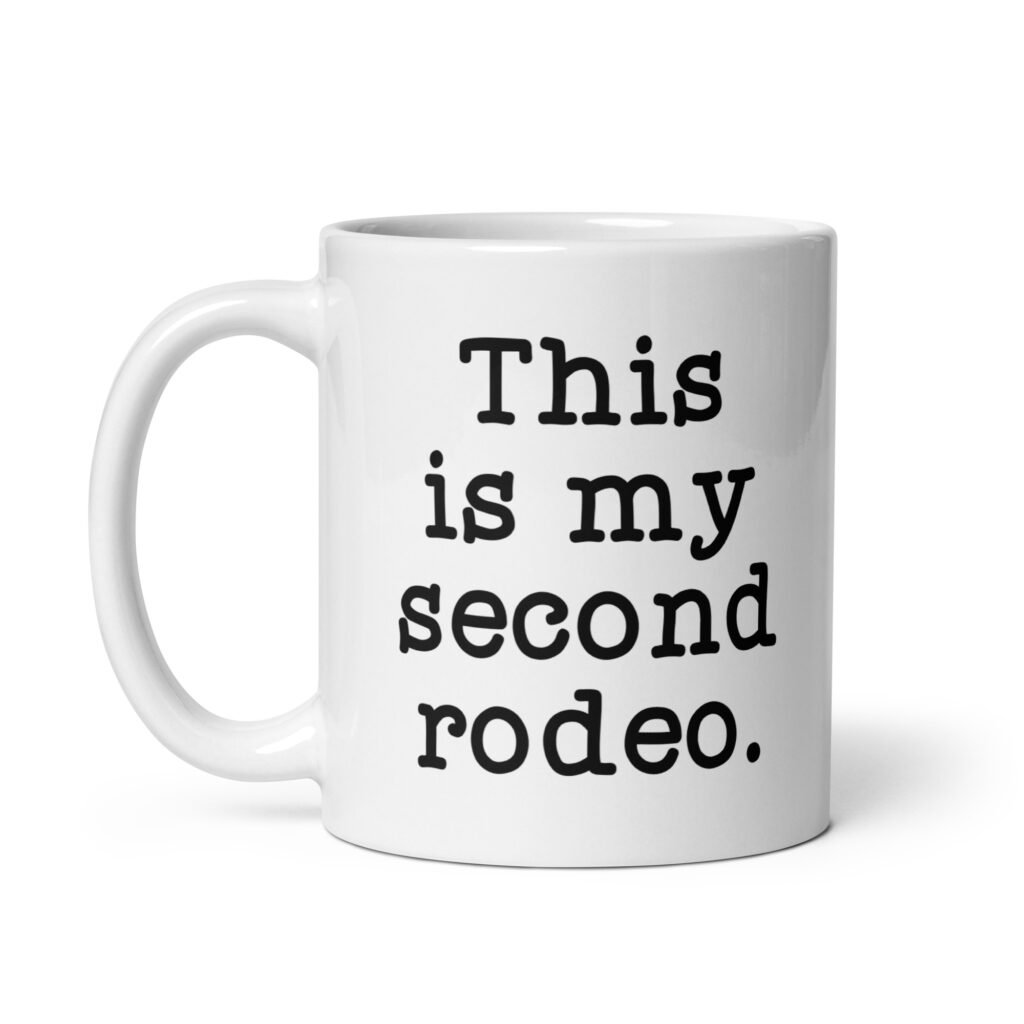 White ceramic mug with the text 'This is my second rodeo.' printed on both sides of the mug.