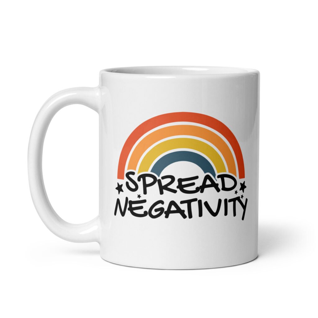 White ceramic coffee mug with a graphic of a rainbow and the words 'Spread negativity' printed on both sides.