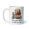 White ceramic coffee mug with an image of grey haired older woman enjoying a bite of a piece of cake with the words 'I hope your cake is as moist as I am' printed on both sides.