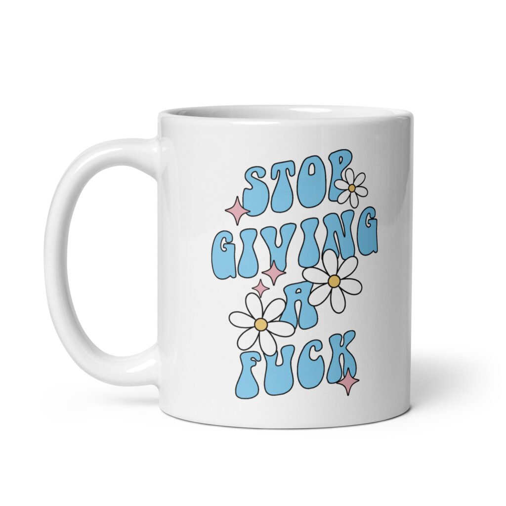 White ceramic coffee mug with a retro daisy and star design and the text 'Stop giving a fuck' printed on both sides.