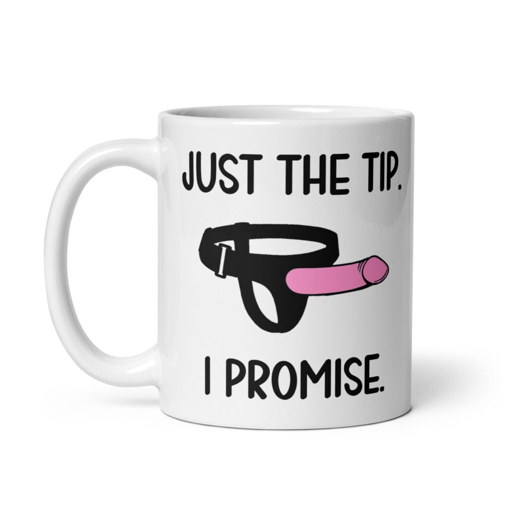 White ceramic coffee mug that has an image of a strap-on dildo and the words 'Just the tip. I promise.' printed on both sides.