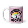 Pink and white ceramic coffee mug with a graphic of a kawaii style unicorn and a pastel rainbow with the text 'Everything is fucked' printed on both sides. The background is pink.