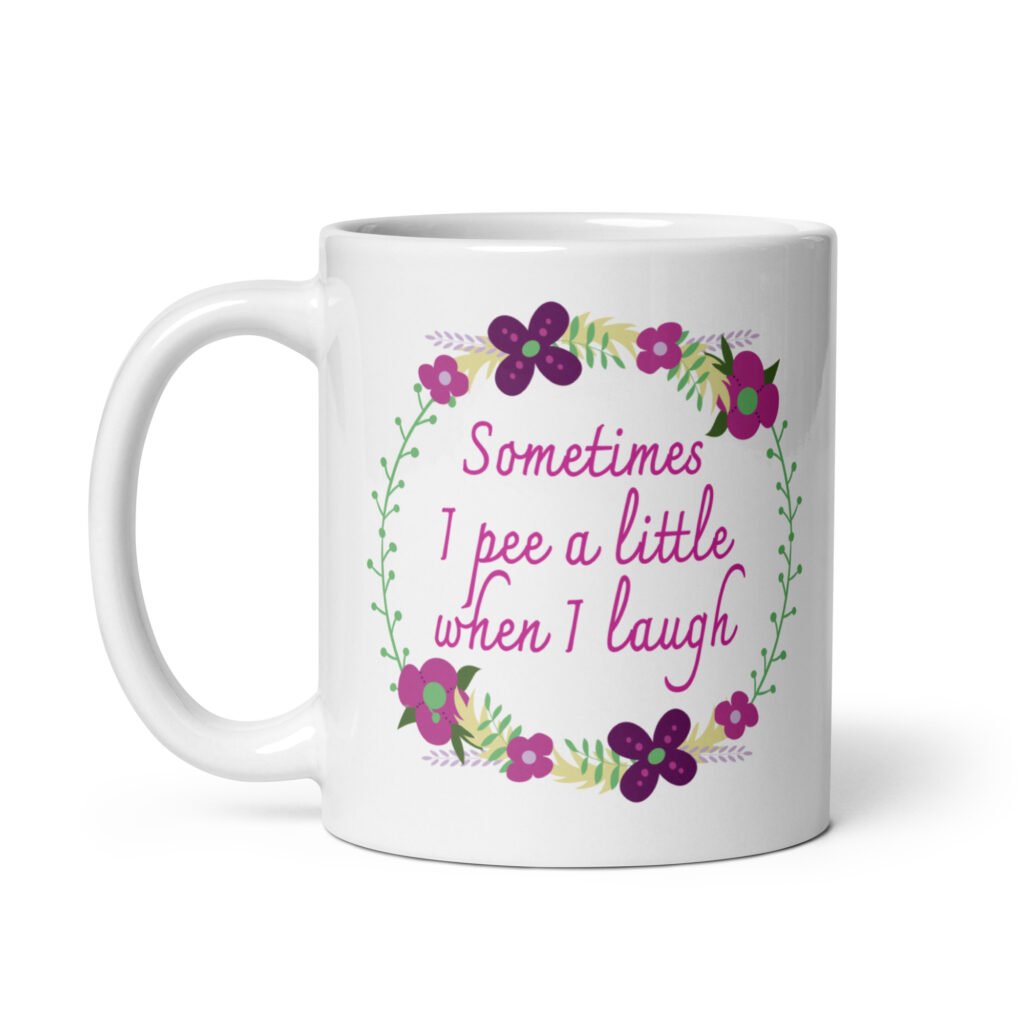 White ceramic coffee mug that has a colorful minimalistic style line drawing floral wreath with the text 'Sometimes I pee a little when I laugh' printed in the center of the wreath. The graphics are printed on both sides of the mug.