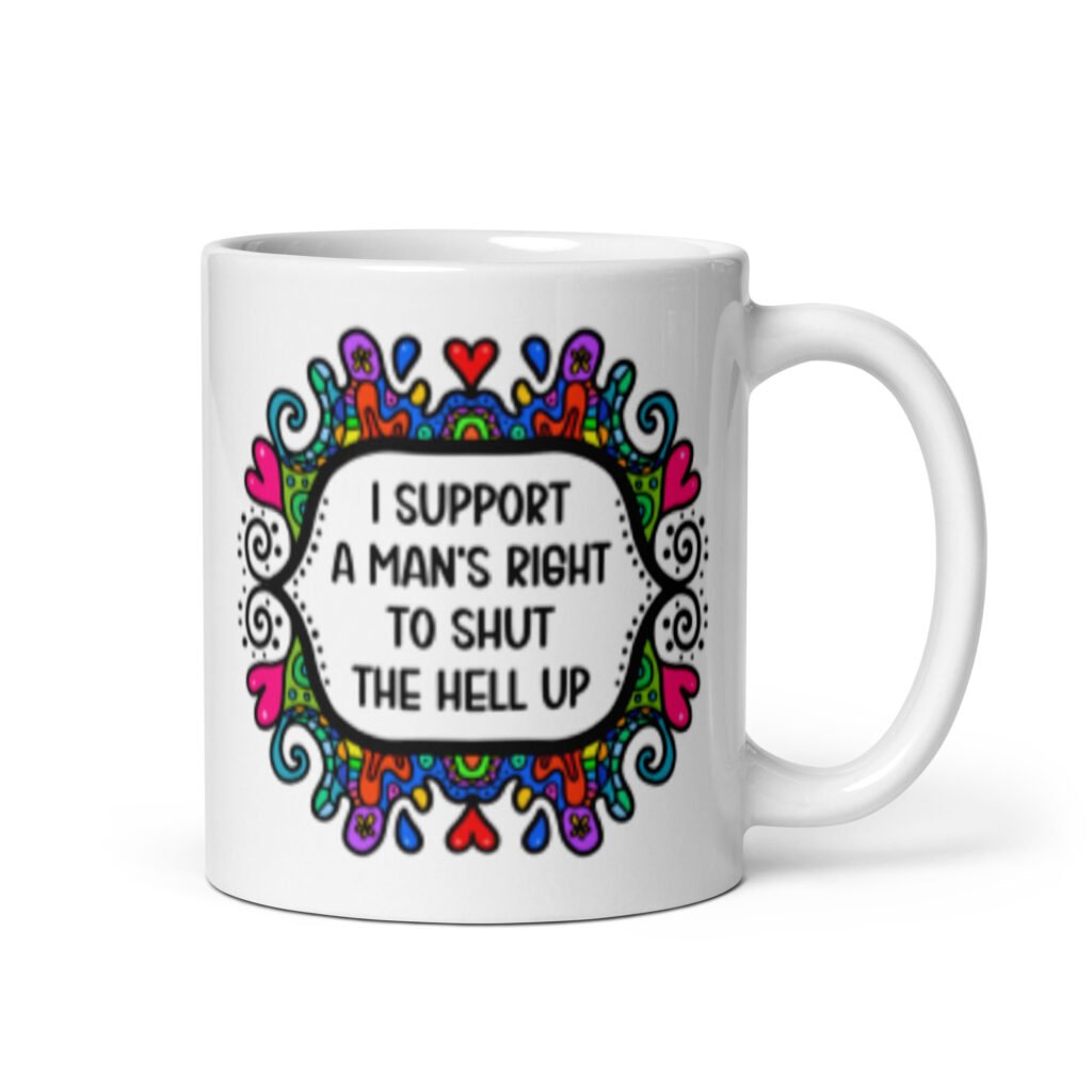 White ceramic mug with a colorful doodle graphic and the words 'I support a man's right to shut the hell up.' The design is printed on both sides of the mug.