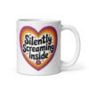 White ceramic coffee mug with a colorful graphic that says 'Silently screaming inside'. The graphics are printed on both sides of the mug.