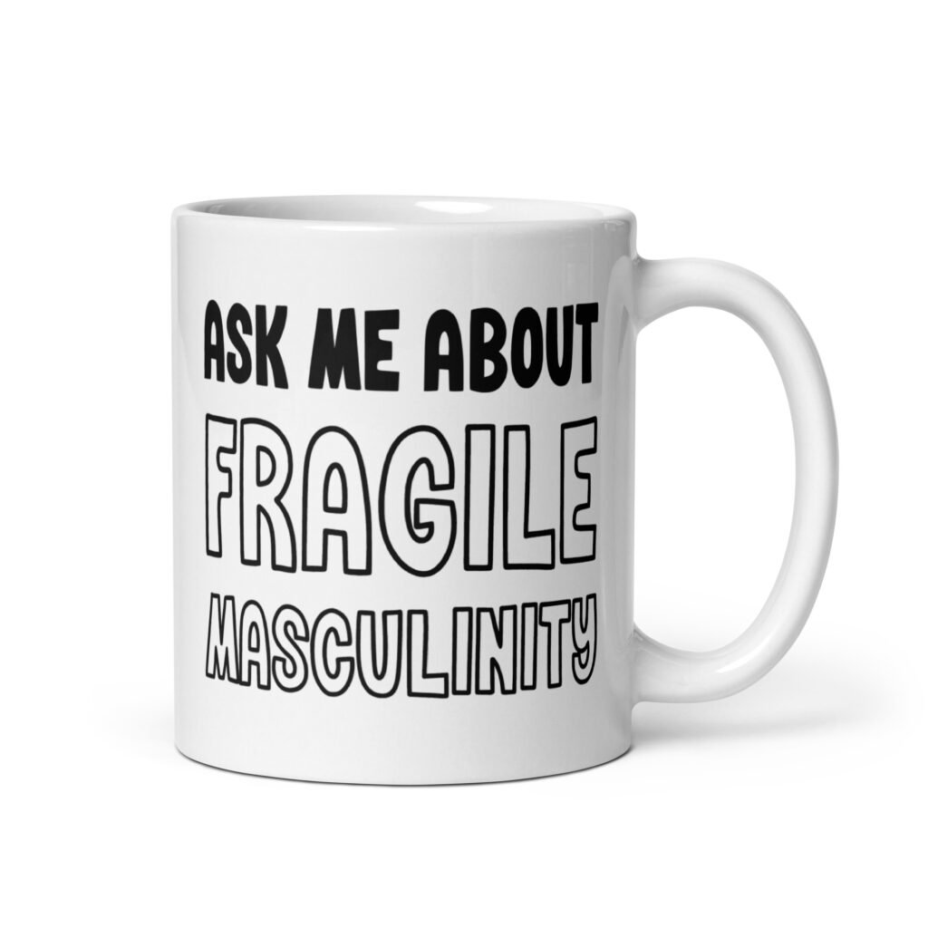 White ceramic coffee mug with the text 'Ask me about fragile masculinity' printed on both sides.